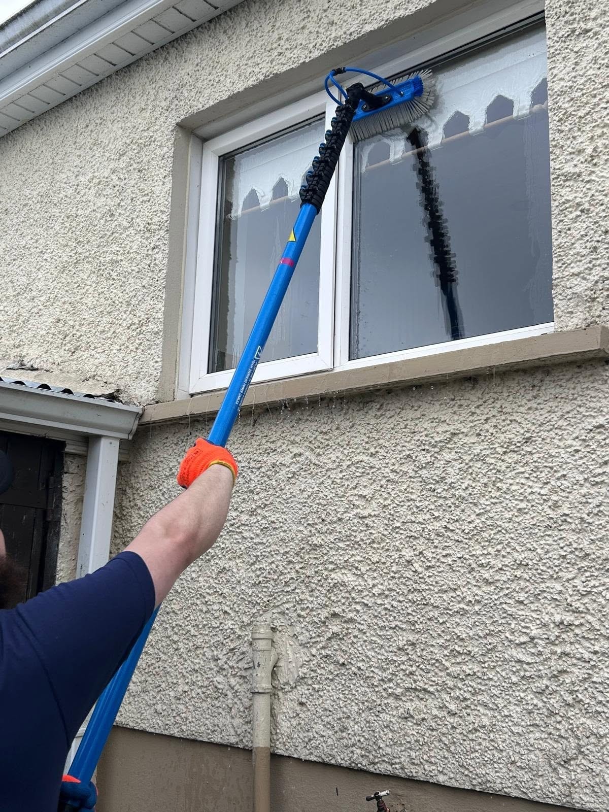 Professional window cleaning in progress on a house